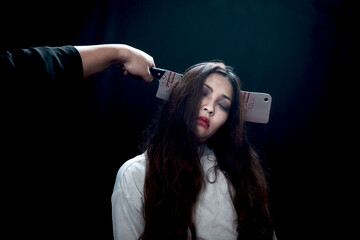 Beautiful black long hair woman with knife in head wearing white ghost spooky costume, scary dead...