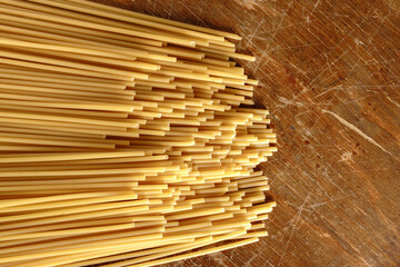 Włoski makaron Bucatini na drewnianym stole