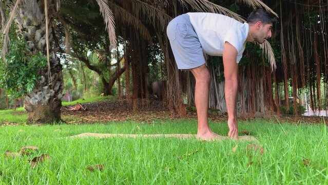 Joven indio entrenando yoga. Sesi&oacute;n de fitness en colchoneta en el parque. Relax al aire libre para una buena salud. Ejercicios para una mejor movilidad por las ma&ntilde;anas en verano en canarias. 