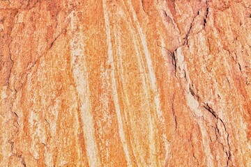 Rock texture. Stone grunge background. Light brown rough backdrop. Red ginger pattern. Fragment of a mountain close-up. Rusty surface formation of a wall with cracks and layers. Copy space for text