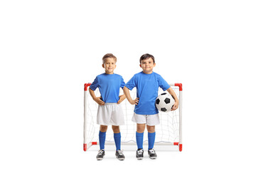 Little boys in football clothes posing in front of a mini goal