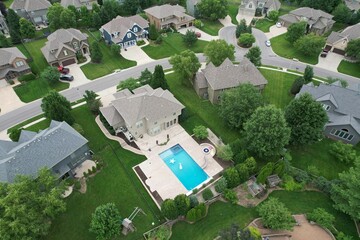 an aerial shot of a house and swimming pool in the suburbs © Brecken Pingel/Wirestock Creators