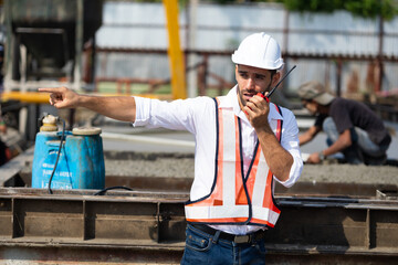 radio transmitter. Hispanic latin architect construction Engineering man in hardhat talking on walkie talkie at factory facilities. Heavy Industry Manufacturing Factory. Prefabricated concrete walls