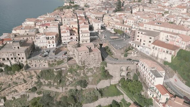 4k 25fps footage: aerial view of the medieval village of Pizzo in Calabria with its Murat castle, the Caribbean sea, the highway behind. The town is overlooking the sea.