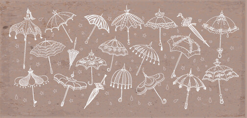 Collection of doodle vintage umbrellas on brown parcel paper background. Vector sketch illustration. © elinacious