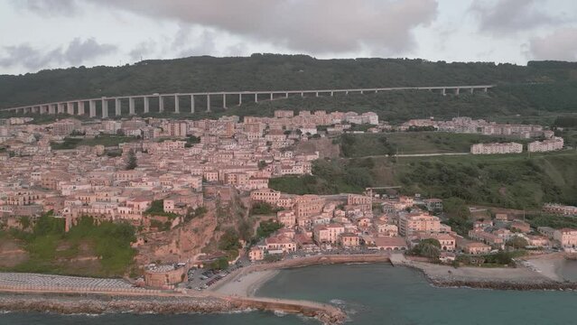 4k 25fps footage: aerial view of the medieval village of Pizzo in Calabria with its Murat castle, the Caribbean sea, the highway behind. The town is overlooking the sea.