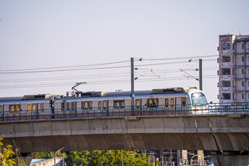 locked shot of metro crossing an overhead bridge at a rapid speed showing how the public tranport...
