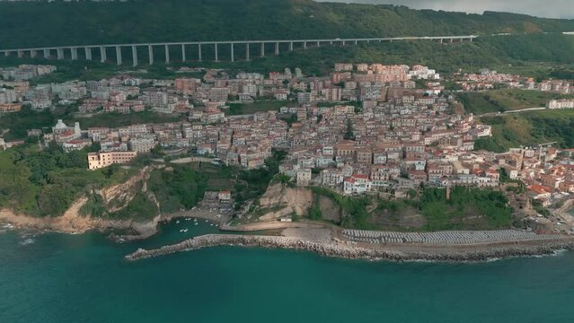 4k 25fps footage: aerial view of the medieval village of Pizzo in Calabria with its Murat castle, the Caribbean sea, the highway behind. The town is overlooking the sea.