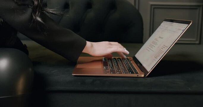 Close-up shot of a female lawyer's hands typing on a laptop while sitting in a modern and luxurious office. Woman touching fingers and texting on computer keyboard. The concept of work