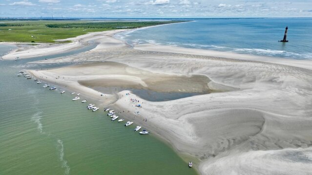 Aerial view of Folly Beach, North Carolina, on a summer day, showcasing the sandbar and lighthouse