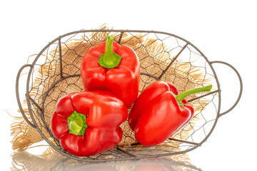 Three red bell peppers in a basket, macro, isolated on white background.
