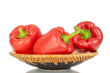 Several red bell peppers with ceramic plate, macro, isolated on white background.