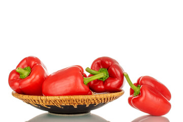 Several red bell peppers with ceramic plate, macro, isolated on white background.