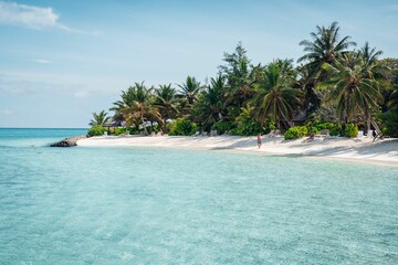 Stunning view of a beach in the Maldives featuring vibrant blue water and a white sand beach