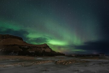 Fototapeta na wymiar aurora borealis in the night sky above Reykjavik, Iceland, with stars twinkling in the background