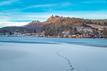 Fototapeta na wymiar Winter landscape of a frozen lake with colorful small fishing houses.