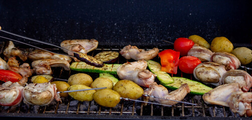 a man is grilling vegetables and meat. Selective focus.
