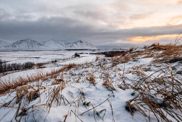 Breathtaking view of an icy snow-covered field in Reykjavik, Iceland during a stunning sunset