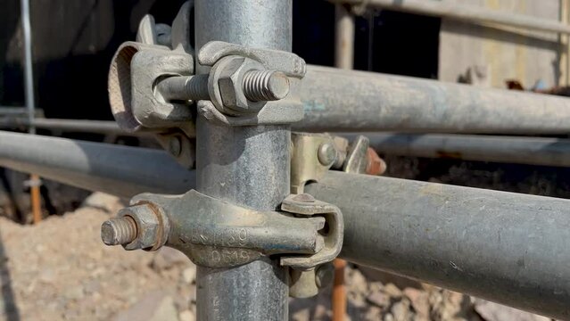Metal scaffolding pipe clamp. Steel scaffolding and mounting parts for strength in construction sites or concert stage supports. Close-up