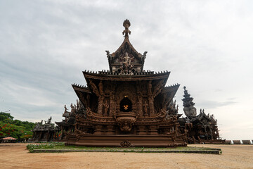 Naklejka premium Sanctuary of Truth, Pattaya, Thailand, wooden temple by the ocean during sunset on beach of Pattaya. Temple of Truth in Thailand. Beautiful wooden building design.