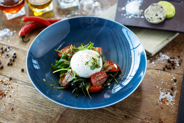 Burrata with paprika-truffle jam and cherry-cluster tomato salad. Delicious healthy Italian traditional food closeup served for lunch in modern gourmet cuisine restaurant