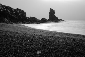 Idyllic beach scene in Reykjavik, Iceland featuring black sand and a foggy weather