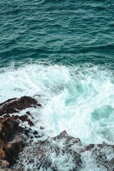 Seascape featuring the crashing waves of the ocean onto a rocky beachfront.