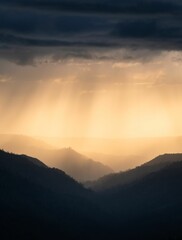 an image of sunset in the mountains with dark clouds and light coming through the clouds