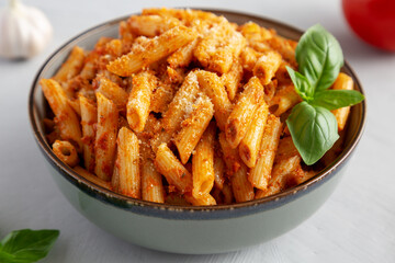 Homemade Tomato Pesto Pasta with Cheese and Basil in a Bowl, side view.