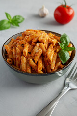 Homemade Tomato Pesto Pasta with Cheese and Basil in a Bowl, side view. Close-up.