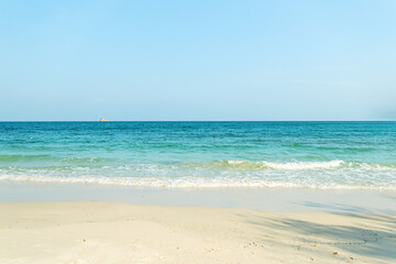 Fototapeta na wymiar Turquoise sea water with white sand beach and blue sky. Horizon line