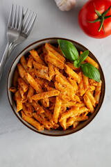 Homemade Tomato Pesto Pasta with Cheese and Basil in a Bowl, top view. Flat lay, overhead, from above.