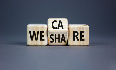 We share and care symbol. Concept word we share we care on wooden block. Beautiful grey table grey...