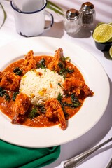 Bowl of steaming, freshly cooked rice accompanied by shrimp in tomato sauce