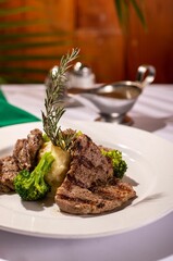 Delicious meal of meat and broccoli with mashed potatoes on a white plate, ready to be enjoyed