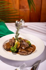 Delicious meal of meat and broccoli with mashed potatoes on a white plate, ready to be enjoyed
