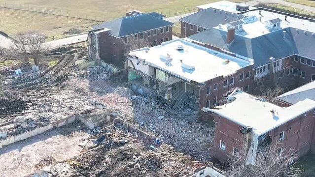 Ruble and outer wall remnants aerial video with shift to overhead view of demolition