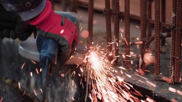 Process of welding metal of the master in gloves next to the fence