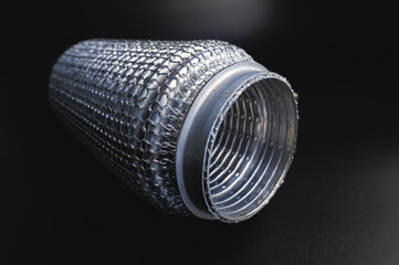 Intermediate flexible connection of the muffler exhaust line. Black gradient background. selective focus