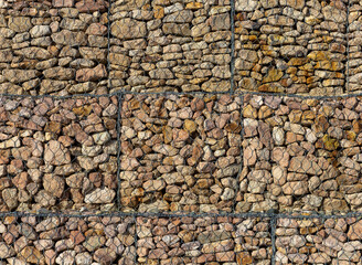 Gabions, mesh structures made of stones that strengthen the slopes, from the sliding of the ground .  on a mountain winter road.