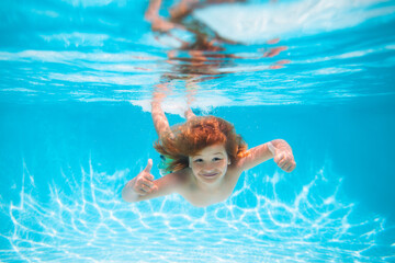 Fototapeta na wymiar Summer kids in water in pool underwater. Child swim and dive underwater in the swimming pool.