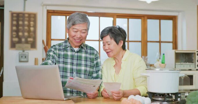 Asian elderly couple look bills