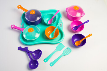 Children's multi-colored plastic toy tableware on a white background.