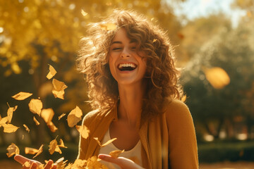 Casual joyful woman having fun throwing leaves in autumn at city park. High quality photo