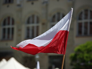National flag of Poland waves on wind in the city