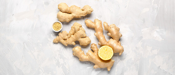 Fresh ginger roots, half of lemon and bowl with dried powder on grunge background