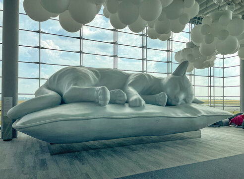 Paris, France &ndash; June 12, 2023: Horizontal view of French artist Charles P&eacute;tillon's In&egrave;s an iconic beautiful sleeping cat sculpture at Terminal 2E at Paris-Charles de Gaulle airport.