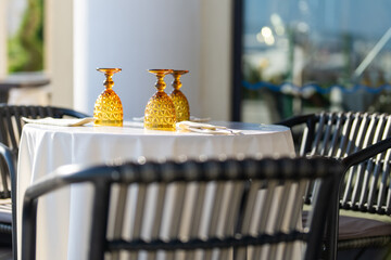 A table in a restaurant on the outdoor terrace. Street restaurant with empty glasses waiting for guests. Street Cafe.