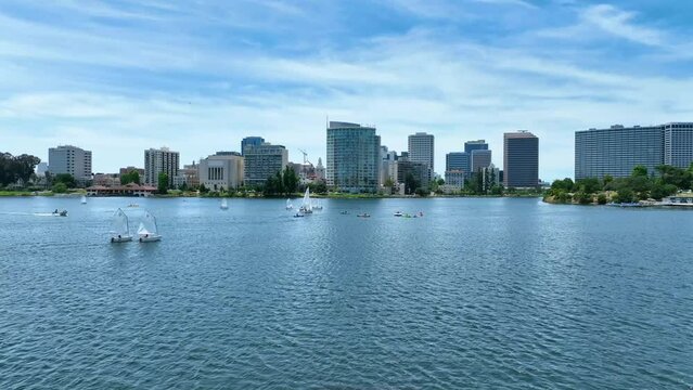 Boaters and kayakers sailing around Lake Merrit dolly shot toward Oakland City