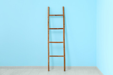 Wooden ladder near blue wall in room